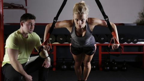 A girl doing exercise with her fitness trainer